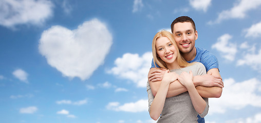 Image showing couple hugging over sky and heart shaped cloud