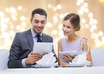 Image showing couple with menu on tablet computers at restaurant