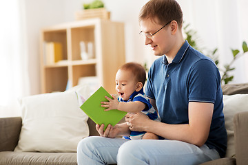 Image showing happy father and little baby son with book at home