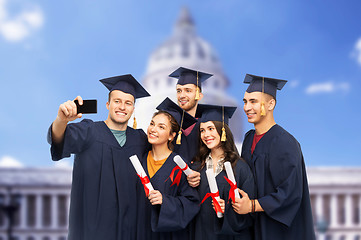 Image showing graduates with diplomas taking selfie by cellphone