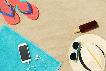 Image showing smartphone, hat, flip flops and shades on beach