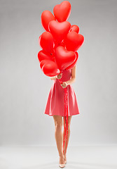 Image showing young woman with red heart shaped balloons