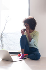 Image showing black woman in the living room on the floor