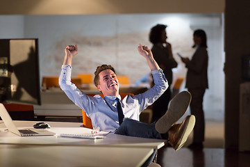 Image showing businessman sitting with legs on desk at office