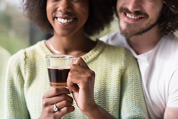 Image showing happy multiethnic couple relaxing at modern home indoors