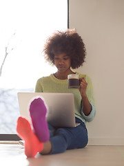 Image showing black woman in the living room on the floor