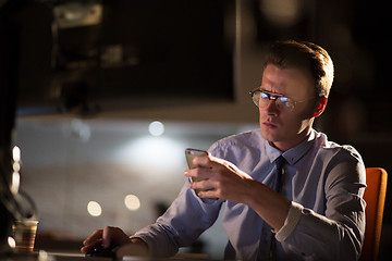 Image showing man using mobile phone in dark office