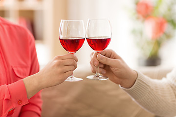 Image showing hands of couple with red wine glasses toasting 