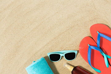 Image showing straw hat, flip flops and sunglasses on beach sand