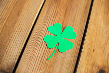 Image showing green paper four-leaf clover on wooden background