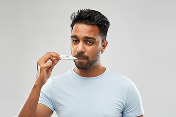 Image showing man measuring oral temperature by thermometer