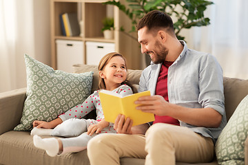 Image showing happy father and daughter reading book at home