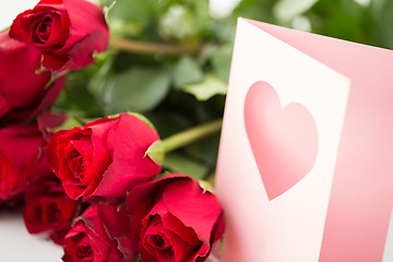 Image showing close up of red roses and greeting card with heart