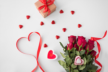 Image showing close up of red roses, gift, candies and candle