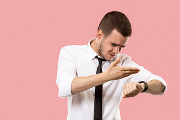 Image showing Handsome businessman checking his wrist-watch Isolated on pink background