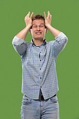 Image showing Man having headache. Isolated over green background.