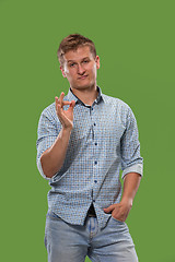 Image showing The happy businessman standing and smiling against green background.