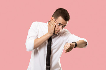 Image showing Handsome businessman checking his wrist-watch Isolated on pink background