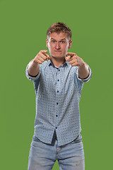 Image showing The overbearing businessman point you and want you, half length closeup portrait on green background.