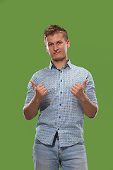 Image showing The happy businessman standing and smiling against green background.