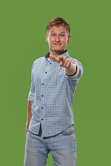 Image showing The happy business man point you and want you, half length closeup portrait on green background.