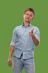 Image showing The happy businessman standing and smiling against green background.