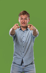Image showing The happy business man point you and want you, half length closeup portrait on green background.
