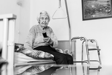 Image showing Elderly 96 years old woman operating TV or DVD with remote control