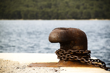 Image showing Old and rusty mooring post