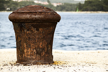 Image showing Old and rusty mooring post