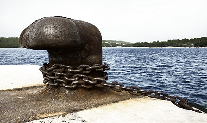 Image showing Old and rusty mooring post