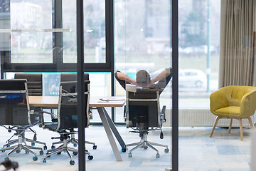 Image showing young businessman relaxing at the desk