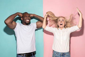 Image showing We won. Winning success happy afro man and woman celebrating being a winner. Dynamic image of caucasian female and male model on pink studio.