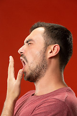 Image showing Beautiful bored man bored isolated on red background