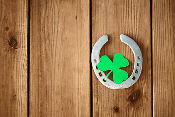 Image showing horseshoe with shamrock on wooden background