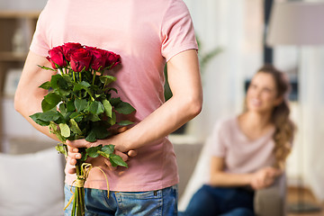 Image showing woman and man with bunch of roses behind his back