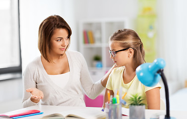 Image showing upset mother talking to daughter doing homework