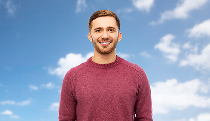 Image showing smiling young man over blue sky background