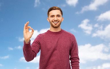 Image showing smiling man showing ok hand sign over blue sky