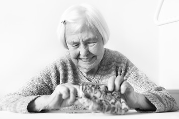 Image showing Detailed closeup photo of unrecognizable elderly womans hands counting remaining coins from pension in her wallet after paying bills.