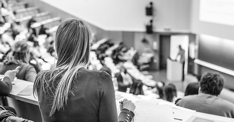 Image showing Audience in the lecture hall. Female student making notes.