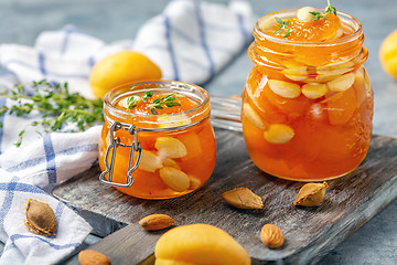 Image showing Apricot homemade jam with almonds in glass jars.