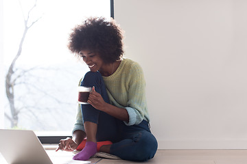 Image showing black woman in the living room on the floor