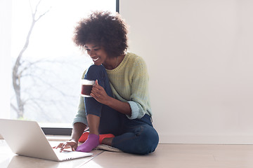 Image showing black woman in the living room on the floor