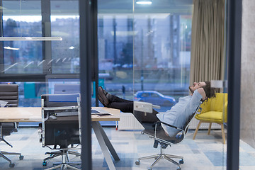 Image showing young businessman relaxing at the desk