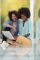 Image showing multiethnic couple using a laptop on the floor