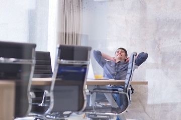 Image showing young businessman relaxing at the desk