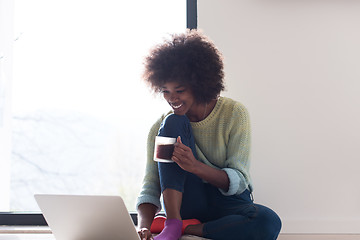 Image showing black woman in the living room on the floor