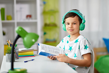 Image showing boy in headphones with textbook learning at home
