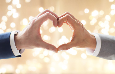 Image showing close up of male gay couple making hand heart